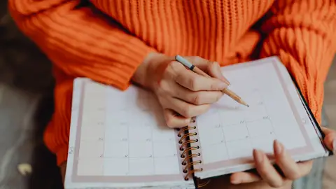 Mujer escribiendo en una agenda Mujer escribiendo en una agenda
