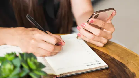 Mujer escribiendo en una agenda Mujer escribiendo en una agenda