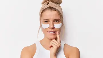 Una mujer joven con parches en el contorno de ojos Una mujer joven con parches en el contorno de ojos