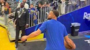 Stephen Curry lanzando un triple desde la otra parte de la cancha