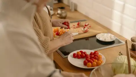 Pareja preparando tomates cherri y burrata Pareja preparando tomates cherri y burrata