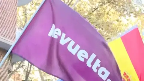 Una bandera de la asociación Revuelta al lado de una Bandera de España Una bandera de la asociación Revuelta al lado de una Bandera de España