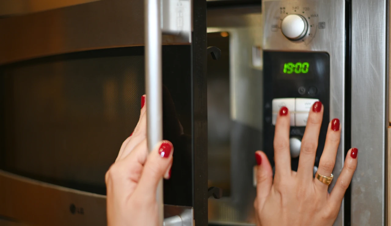 Chica abriendo el microondas