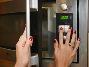 Chica abriendo el microondas Chica abriendo el microondas