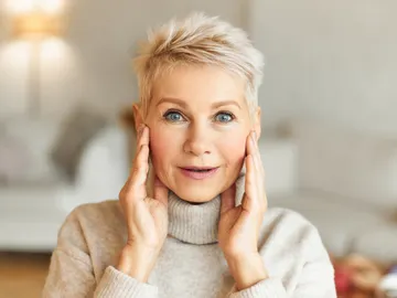 Mujer tensándose la cara Mujer tensándose la cara