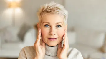 Mujer tensándose la cara Mujer tensándose la cara