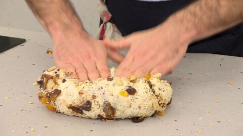 Pasa la mezcla a la encimera, amásala un poco, añade poco a poco todos los frutos