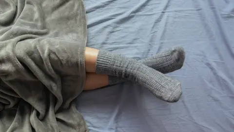 Persona durmiendo con calcetines Persona durmiendo con calcetines