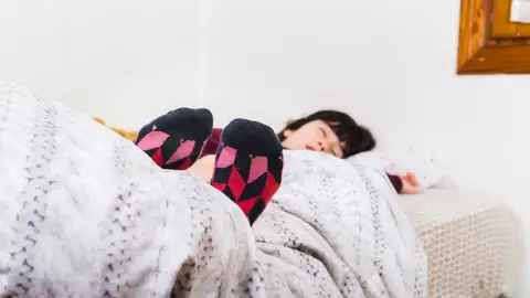 Persona durmiendo con calcetines Persona durmiendo con calcetines