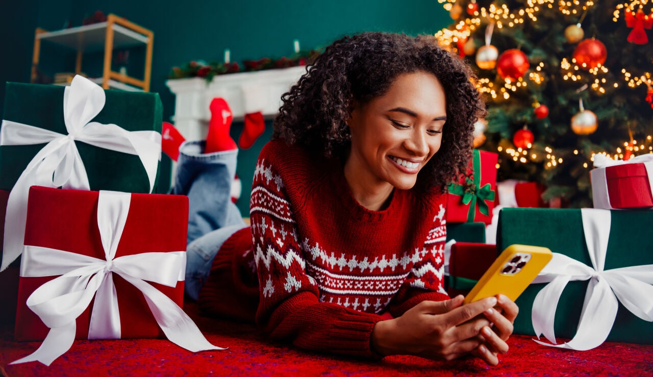 Una mujer con su tel&eacute;fono m&oacute;vil en Navidad