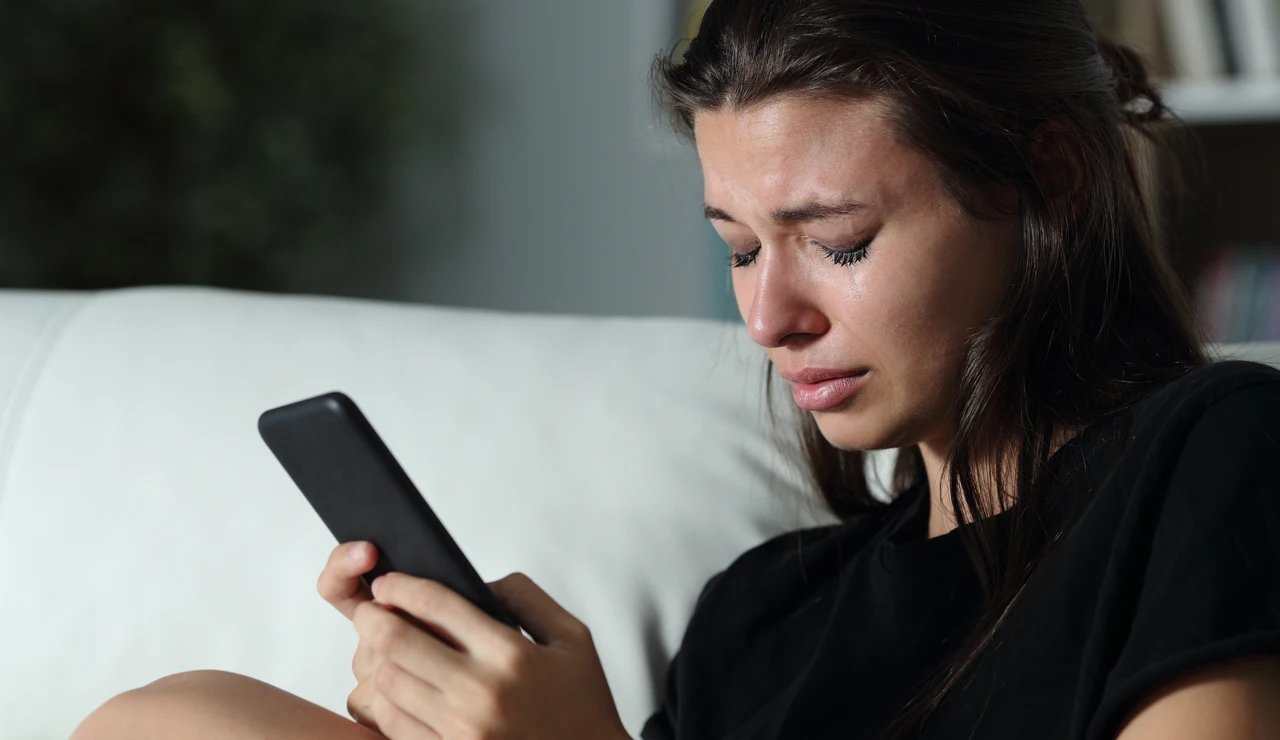Una chica grabándose mientras está con el teléfono móvil