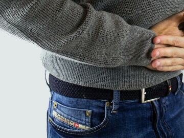 Imagen de archivo de una persona quej&aacute;ndose del est&oacute;mago