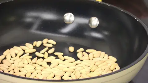 Calienta una sartén sin aceite, introduce los piñones Calienta una sartén sin aceite, introduce los piñones