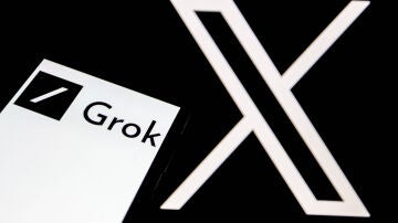 El logo de Grok aparece en la pantalla de un smartphone, y al fondo, el logo de la red social 'X'