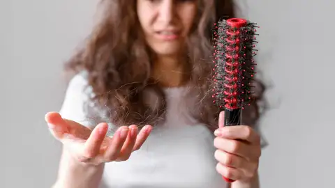 Mujer joven que se le cae el pelo Mujer joven que se le cae el pelo