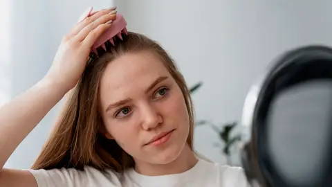 Mujer haciéndose un masaje capilar Mujer haciéndose un masaje capilar