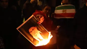 Un manifestante quemando la imagen del líder iraní Ali Jameneí Un manifestante quemando la imagen del líder iraní Ali Jameneí
