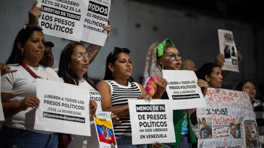 Personas sostienen carteles afuera de El Helicoide este lunes, en Caracas (Venezuela)