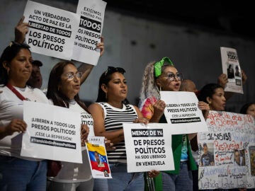 Personas sostienen carteles afuera de El Helicoide este lunes, en Caracas (Venezuela)
