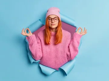 Una mujer con los ojos cerrados en posición de meditación Una mujer con los ojos cerrados en posición de meditación