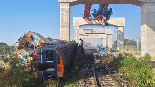 Una gr&uacute;a cae sobre un tren en Tailandia.