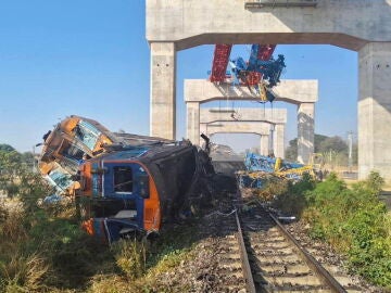 Una gr&uacute;a cae sobre un tren en Tailandia.