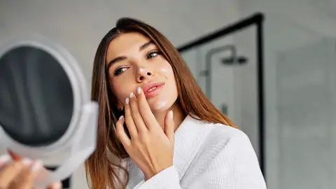 Mujer poniéndose un cosmético Mujer poniéndose un cosmético