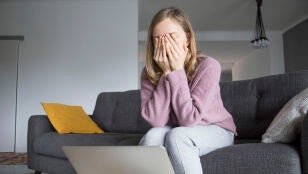 Una mujer triste se cubre la cara con la manos