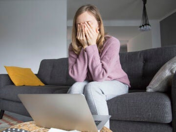 Una mujer triste se cubre la cara con la manos