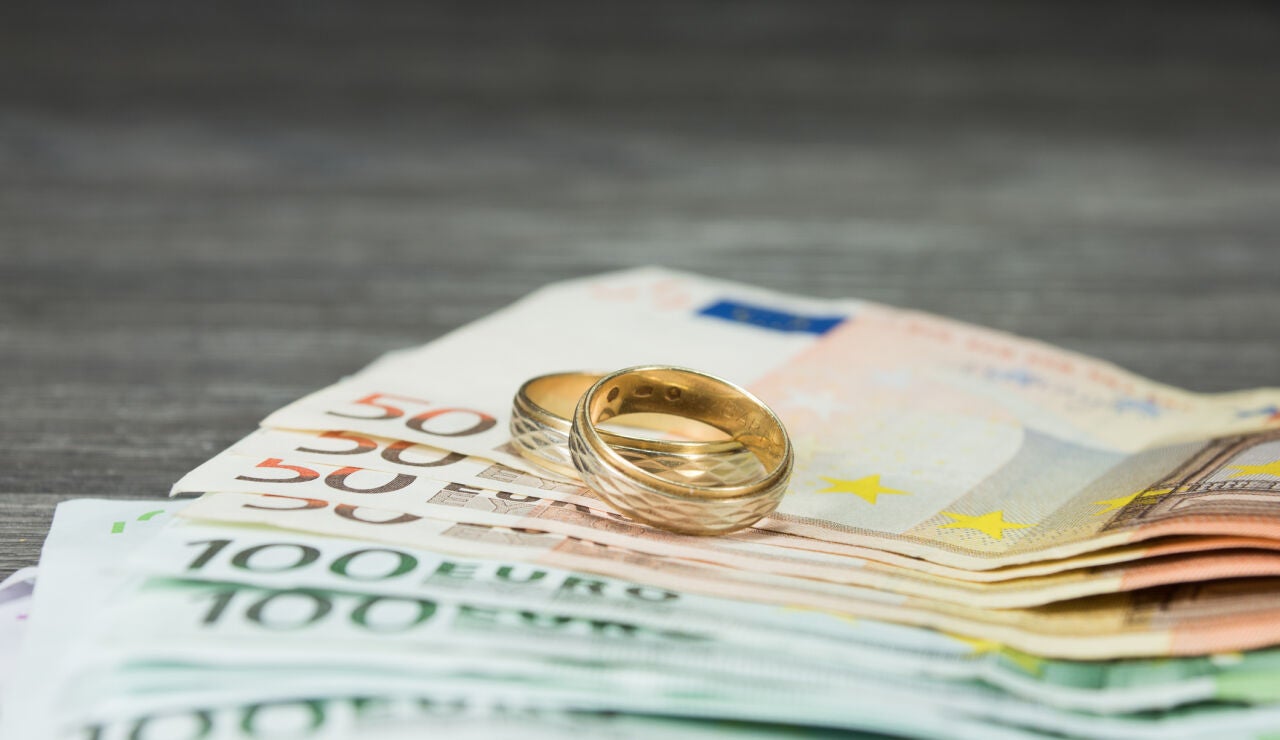 Anillos de boda sobre dinero en efectivo
