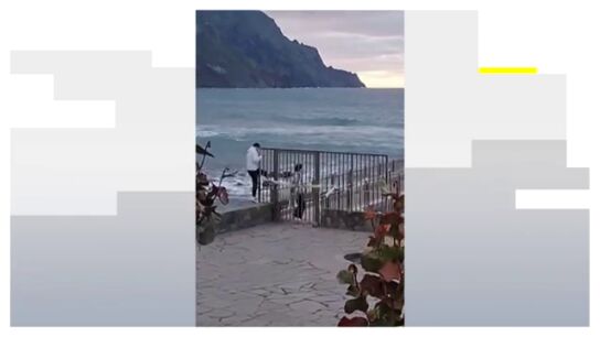 Dos personas se saltan el vallado de seguridad que da acceso a una playa cerrada por oleaje