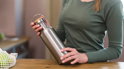 Mujer con una botella de acero inoxidable Mujer con una botella de acero inoxidable