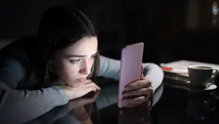 Una adolescente mirando el móvil