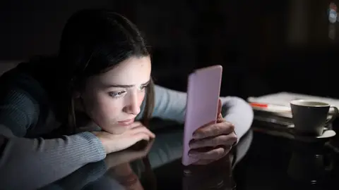 Una adolescente mirando el móvil Una adolescente mirando el móvil