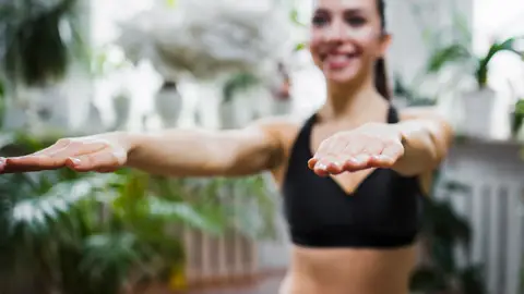 Mujer haciendo ejercicio con los brazos estirados Mujer haciendo ejercicio con los brazos estirados
