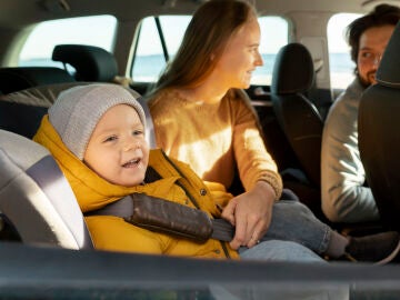 Ni&ntilde;o con abrigo en la sillita del coche