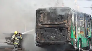 Un bombero apaga las llamas en un autobús Un bombero apaga las llamas en un autobús