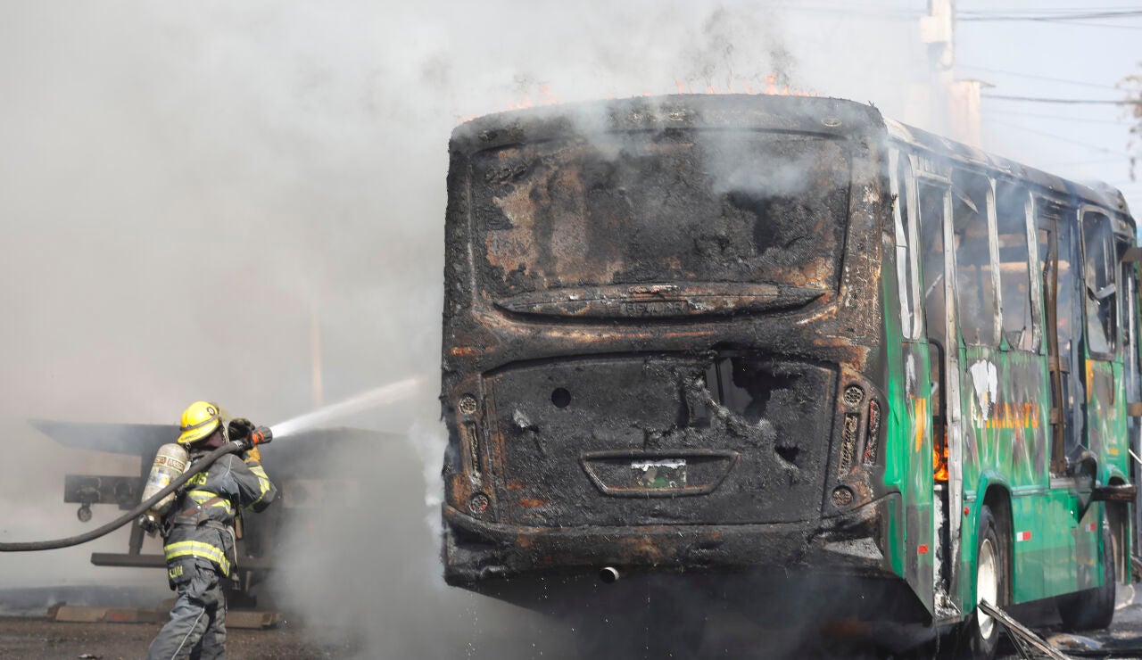 Un bombero apaga las llamas en un autob&uacute;s