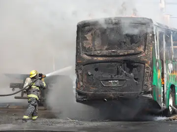 Un bombero apaga las llamas en un autobús Un bombero apaga las llamas en un autobús