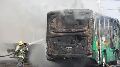 Un bombero apaga las llamas en un autobús Un bombero apaga las llamas en un autobús