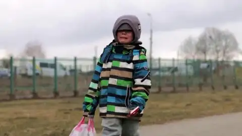 Una infancia bajo asedio: así es ser niño en una guerra de Europa Un niño ucraniano camina por la ciudad fronteriza de Medyka, en Polonia