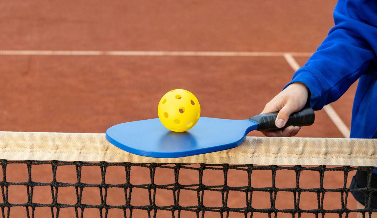 Raqueta y pelota de pickleball sobre la red