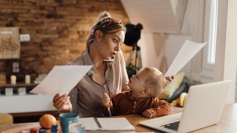 Mujer trabajando y cuidando de su hijo