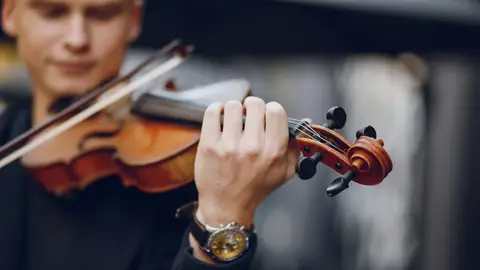 Hombre joven tocando el violín Hombre joven tocando el violín