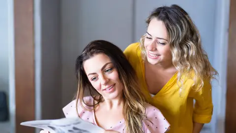 Dos mujeres jóvenes mirando imágenes Dos mujeres jóvenes mirando imágenes