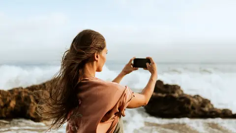 Mujer haciendo una foto del paisaje Mujer haciendo una foto del paisaje