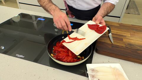 Limpia los piquillos de semillas, córtalos en tiras finas, introdúcelos en la sartén