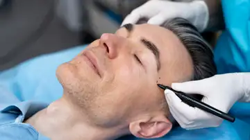 Hombre realizándose retoques estéticos Hombre realizándose retoques estéticos