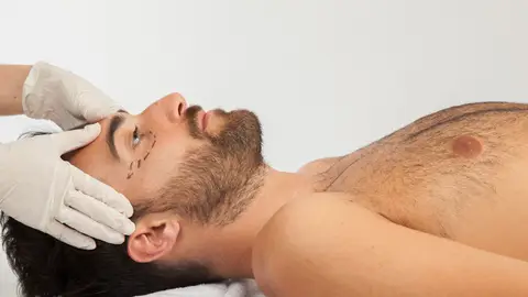 Hombre realizándose retoques estéticos Hombre realizándose retoques estéticos