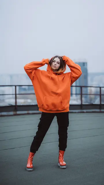 Mujer con un jersey oversize y pantalones ajustdos Mujer con un jersey oversize y pantalones ajustdos